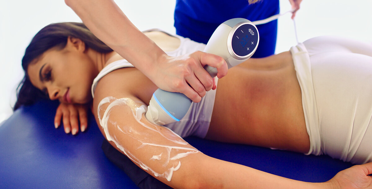 Emtone product being used on the back of a female client\'s arm